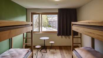 Lichte meerpersoonskamer met uitzicht vanuit het raam in de jeugdherberg Schaan-Vaduz