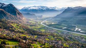 Panoramisch uitzicht over de Rijnvallei Prachtig uitzicht vanaf de heuvel over de Rijnvallei met velden, dorpen en besneeuwde bergen - een natuurlijke idylle in Liechtenstein