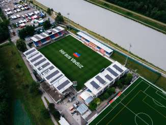 Luchtfoto van het Rheinpark Stadion in Vaduz met "Hoi aus Vaduz" opschrift op het veld en de Rijn op de achtergrond