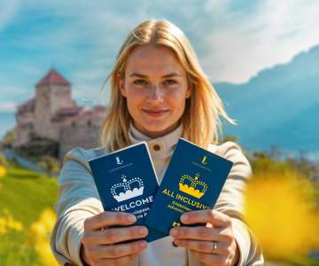 Vrouw presenteert de WELKOM en "ALL INCLUSIVE Belevenispas" voor het kasteel van Vaduz