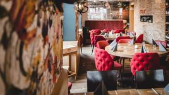 Groothoekopname van het PUR Restaurant & Bar met zijn uitnodigende sfeer en liefdevolle aandacht voor detail.