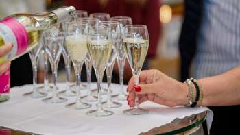 Verschillende champagneglazen worden gevuld op een wit doek