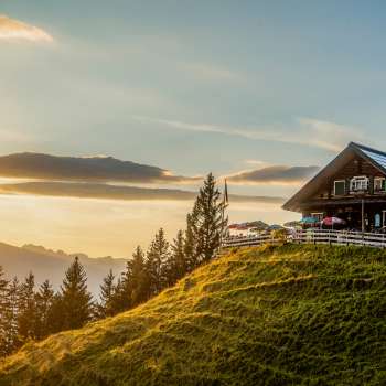 Gadafura hut op een zonnige bergweide met uitzicht op de bergen en zonsondergang