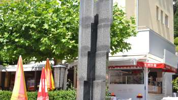 Sculptuur "Monoform 29" van Gottfried Honegger van grijze steen met verticale insnijding - moderne kunst in Vaduz.
