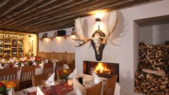 Gezellige restaurantambiance met rustieke houten balken en open haard