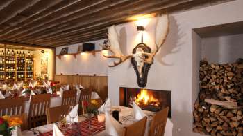 Gezellige restaurantambiance met rustieke houten balken en open haard