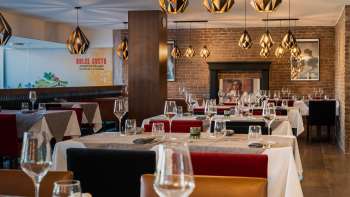 Elegant restaurant met stijlvolle inrichting, witte tafelkleden en open haard voor een gezellige sfeer