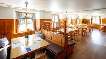 Lichte eetzaal in traditionele stijl met houten lambrisering in restaurant Rössle.