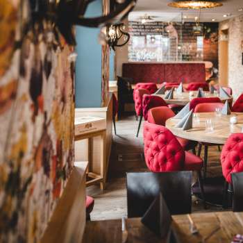 Groothoekopname van het PUR Restaurant & Bar met zijn uitnodigende sfeer en liefdevolle aandacht voor detail.