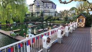 Op afstand bestuurbare boten in het waterbassin van Europa-Park, omringd door vakwerkhuizen en lentebomen