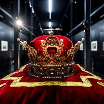 Close-up van de vorstelijke kroon van Liechtenstein op een rood fluwelen kussen met gouden borduursel, tentoongesteld in de Schatkamer