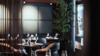 Modern restaurant met stijlvol interieur, comfortabele fauteuils en grote ramen