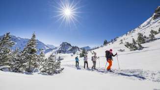 Sneeuwschoenwandelen door het besneeuwde landschap op de Schönberg bij Malbun onder een stralende winterzon.