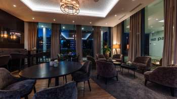  Interieur van het restaurant met moderne houten tafels, comfortabele stoelen en sfeervolle verlichting.