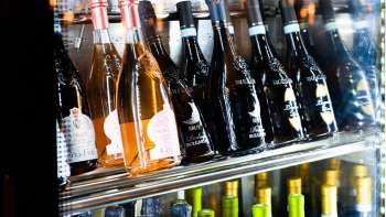 Goed gevulde wijnkoelkast met een selectie rode, witte en rosé wijnen bij Dolce Gusto