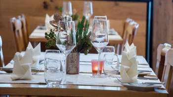 Close-up van een mooi gedekte tafel met glazen, bestek en kleine plantendecoraties