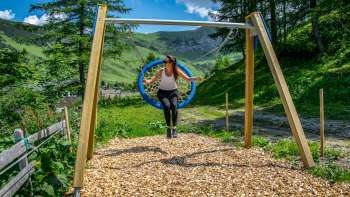 Een vrouw schommelt in de bergen van Liechtenstein en geniet van het uitzicht