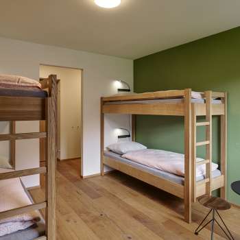Vierpersoonskamer met stapelbed en houten vloer in jeugdherberg Schaan/Vaduz