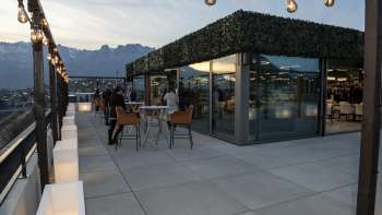 Dakterras van het Casino Royal Restaurant met uitzicht op het omringende berglandschap bij schemering