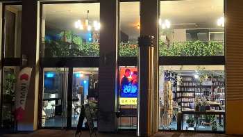 Verlicht buitenaanzicht van de Skino bioscoop in Schaan bij nacht, met grote glazen puien en een uitnodigende sfeer.