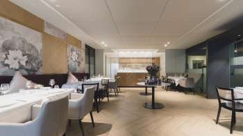 Ruime eetruimte met een elegante sfeer, grote tafels en moderne stoelen