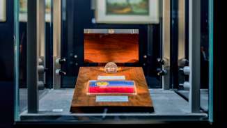 Detailopname van een presentatie van de nationale vlag van Liechtenstein in een glazen kamer in de Schatkamer met een fraaie houten lijst
