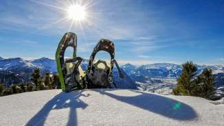 Twee sneeuwschoenen in het besneeuwde Malbun met een panoramisch uitzicht op de Alpen op de Alpspitz in Liechtenstein in de stralende zon