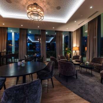  Interieur van het restaurant met moderne houten tafels, comfortabele stoelen en sfeervolle verlichting.