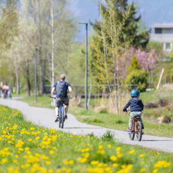 Fietsen met het gezin op het lentefietspad in natuurpark Haberfeld, omringd door bloeiende weiden en bomen.