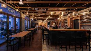 Gezellig interieur van de St. Martins Pub met stijlvolle bar en houten balkenplafond met avondverlichting Gezellig interieur van de St. Martins Pub met stijlvolle bar en houten balkenplafond met avondverlichting