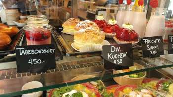 Gevarieerd aanbod van gebak, taarten en verse snacks in de vitrine van Café 44 Café im Hof