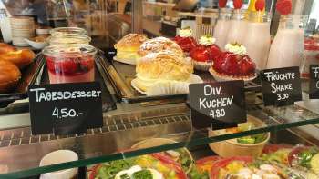 Gevarieerd aanbod van gebak, taarten en verse snacks in de vitrine van Café 44 Café im Hof
