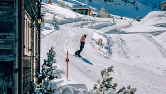 Snowboarder geniet van een zonnige dag op de besneeuwde hellingen in Malbun in Liechtenstein