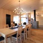 Lichtgekleurd houten interieur met eettafel en open haard in Haus Ochsenkopf in Malbun, Liechtenstein