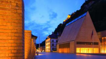 Verlicht parlementsgebouw bij schemering in Vaduz