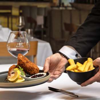 Geserveerd met gepaneerd vlees en frietjes in een moderne presentatie in het Alpspitz restaurant.