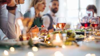 Mensen zitten samen aan een feestelijk gedekte tafel en genieten van een heerlijke maaltijd