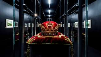 Originele kroon van het Vorstendom Liechtenstein op een rood fluwelen kussen in de tentoonstelling Treasury in Vaduz, indrukwekkend geënsceneerd