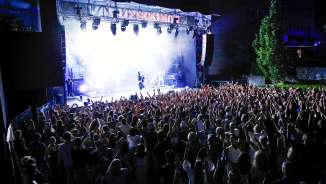 Grote menigte voor verlicht podium tijdens openluchtconcert Vaduz Soundz 2024 in Liechtenstein