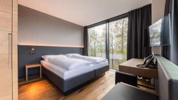 Moderne tweepersoonskamer in Hotel Kommod met uitzicht op het groen