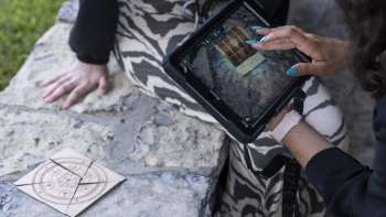 Speler gebruikt iPad om puzzels op te lossen in de Outdoor Adventure Room