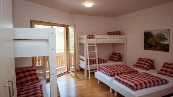 Gezinsvriendelijke meerpersoonskamer met stapelbed en eenpersoonsbedden in het pension op Camping Mittagsspitze.