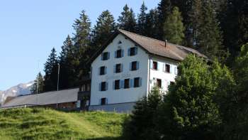 Traditionele bergherberg Sücka midden in een groen landschap en omgeven door bossen