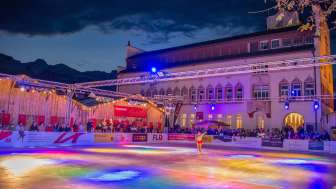 Vaduz on Ice - Schaatsen in de winter in het hart van Liechtenstein Kleurrijke ijsbaan bij "Vaduz on Ice" met lichtshow en schaatser voor het regeringsgebouw in Liechtenstein