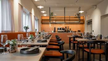 Modern restaurant met open keuken en elegant gedekte tafels