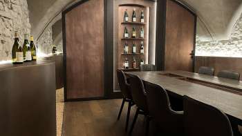 Elegant proeflokaal van de WY Weinbar met gewelfd plafond en elegante houten tafel voor exclusieve wijnproeverijen.