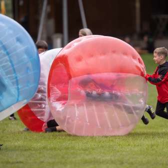 Kinderen spelen bubbelvoetbal in de buitenlucht - plezier en actie op een buitenavontuur in Liechtenstein