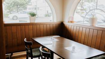 Uitnodigende eetkamer met lichte ramen en rustieke houten meubels