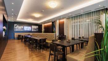 Elegante kamer in het Kommod-restaurant met symmetrische indeling en gezellige sfeer.