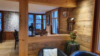 Uitnodigend interieur met houten muren, stijlvolle zithoek en natuurlijke verlichting